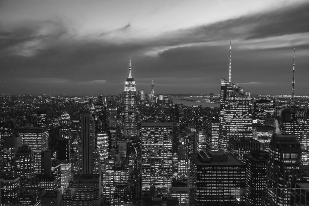 Manhattan skyline visible from Brooklyn during sunset.
